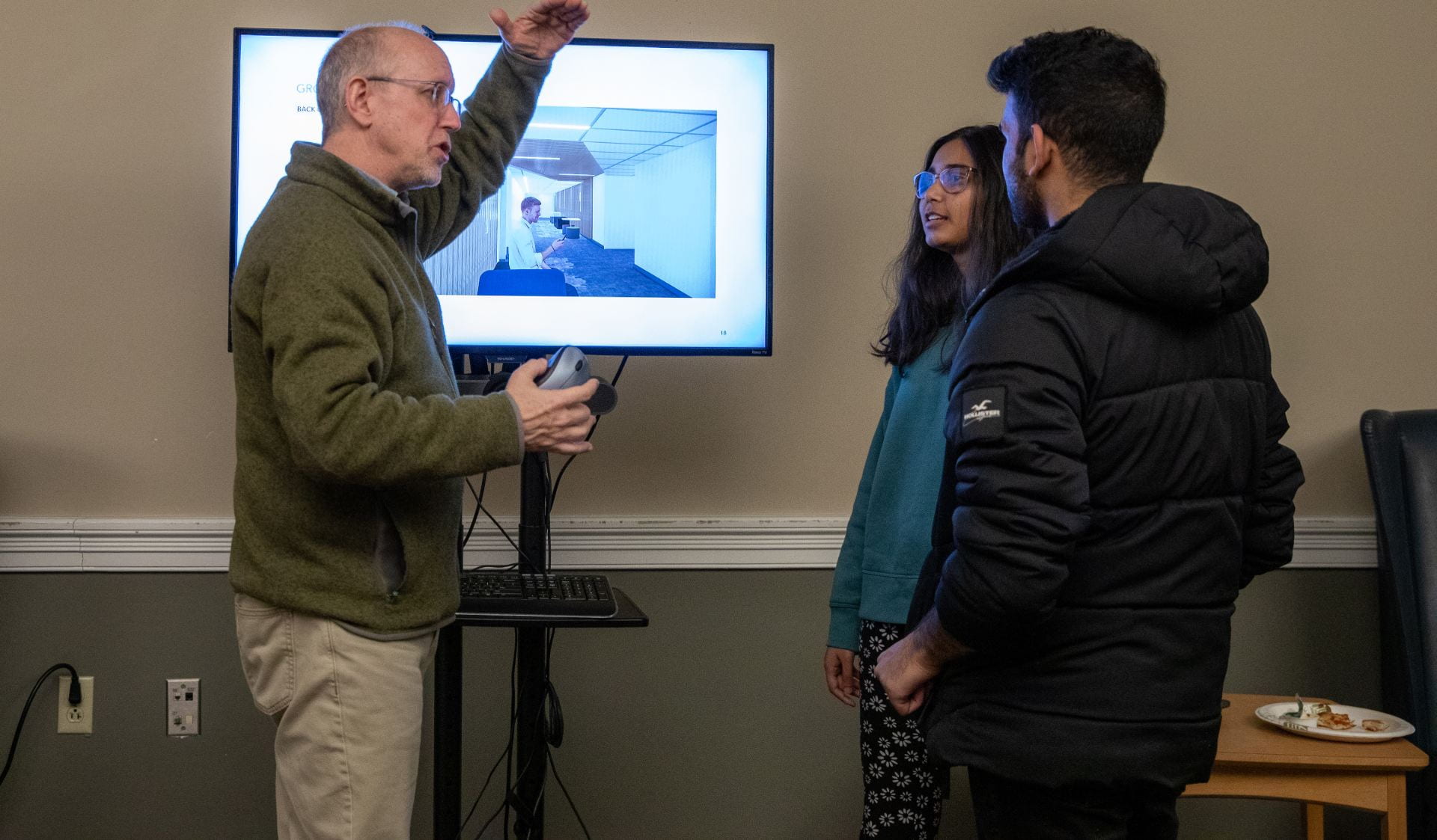 Dean Mather showing students renovation designs on a tv screen
